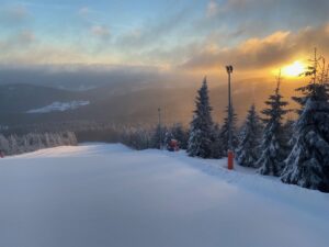 zaśnieżony stok narciarski o zachodzie słońca