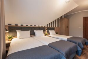 trzy łóżka pojedyncze ułożone obok siebie